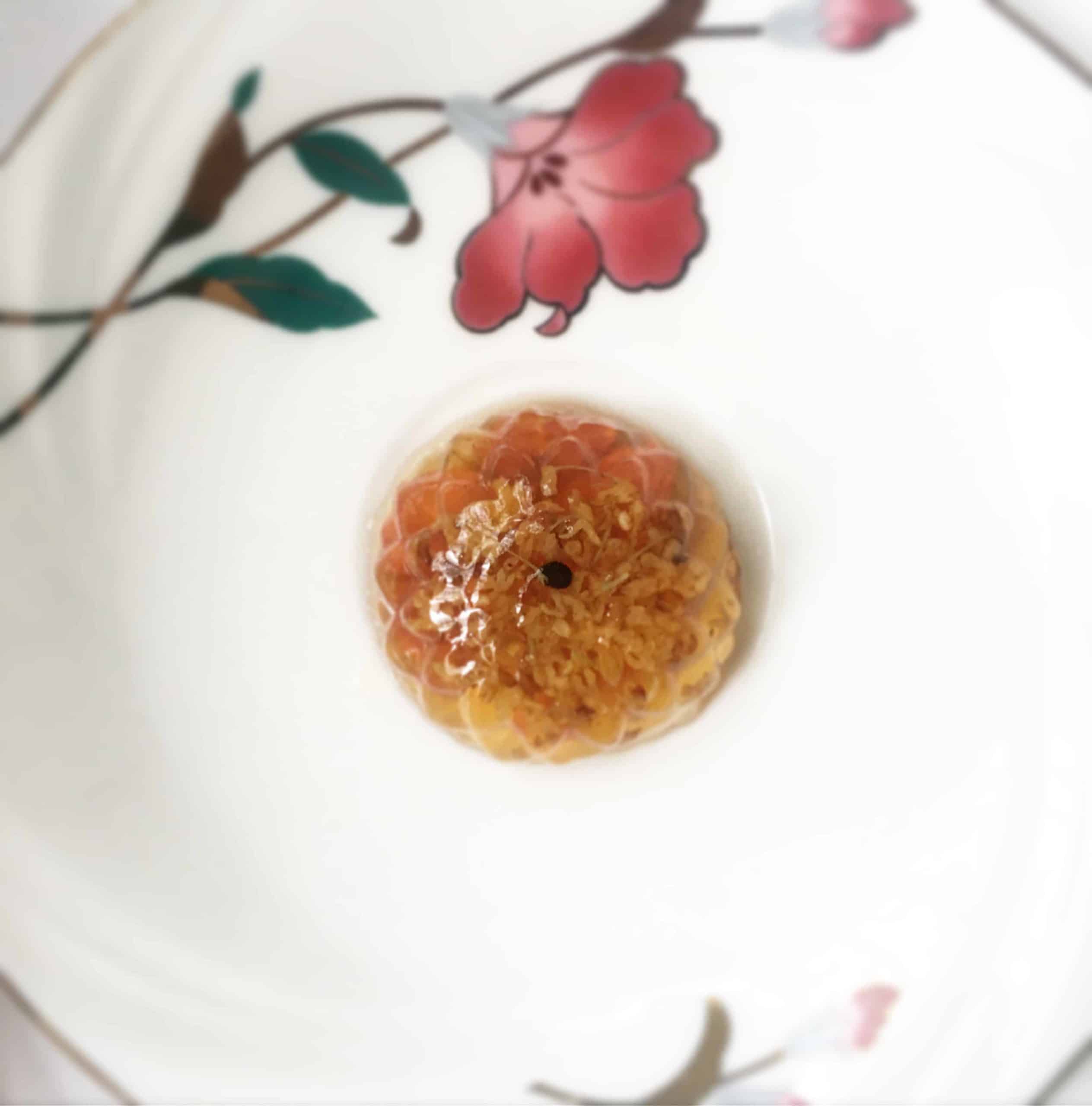 Flower Shaped Osmanthus Konnayku Jelly with Wolfberries on a plate