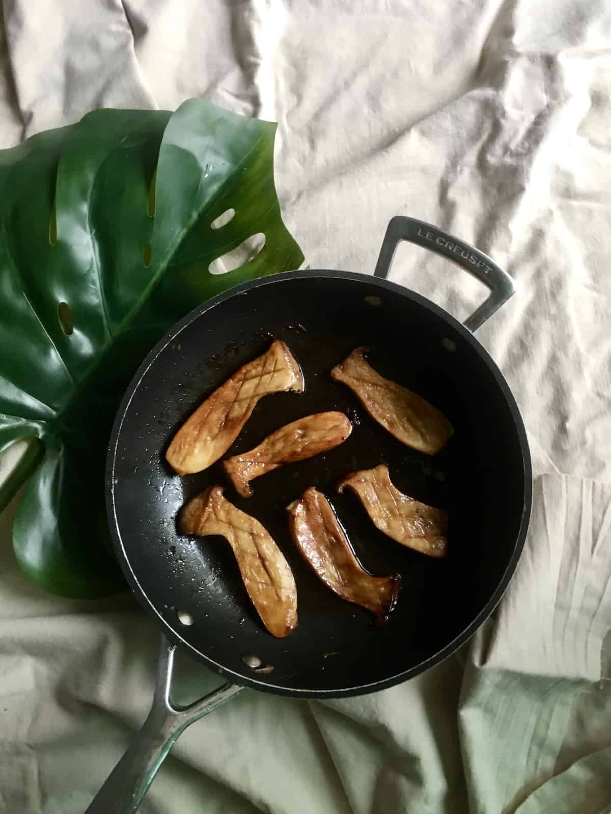 Eryngii mushrooms seared in a butter and soy sauce, served on a pan.