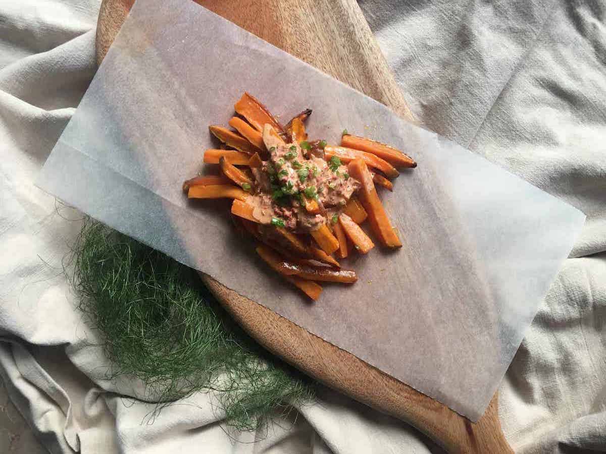 Sweet potato fries with sambal mayonnaise on a serving board.