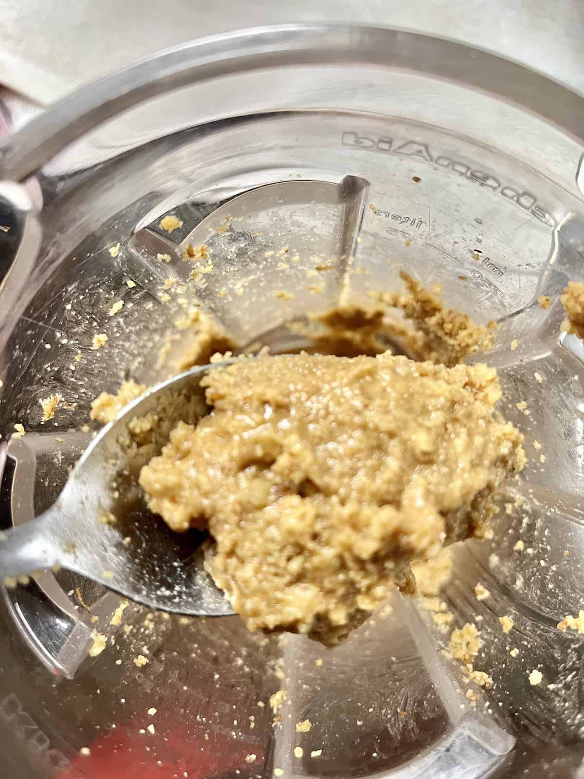Close-up of over-blended peanut powder which has turned into peanut butter.