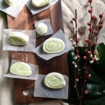 A few steamed spiral mantou buns on a serving board.