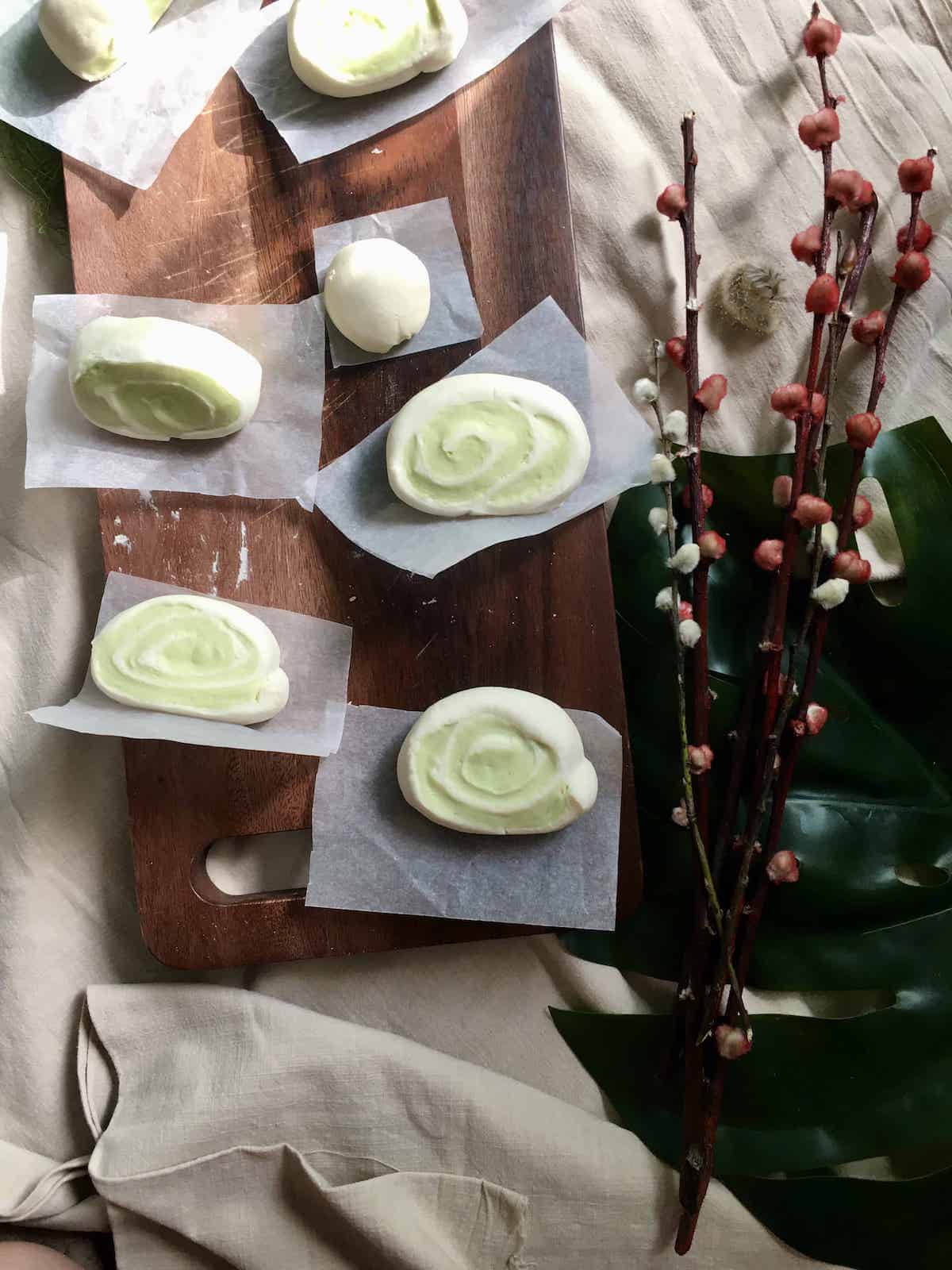 6 green & white mantou buns on a serving board.
