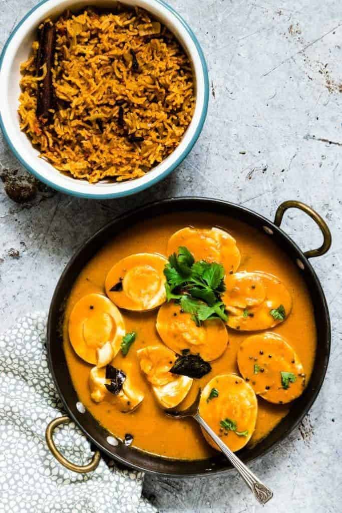 A pan of egg curry and a bowl of rice