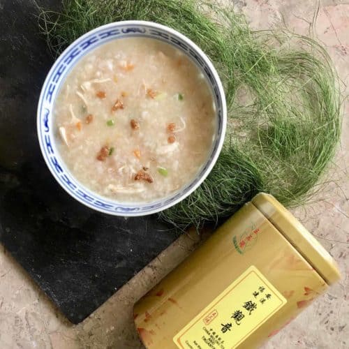 A bowl of chicken rice porridge and tea