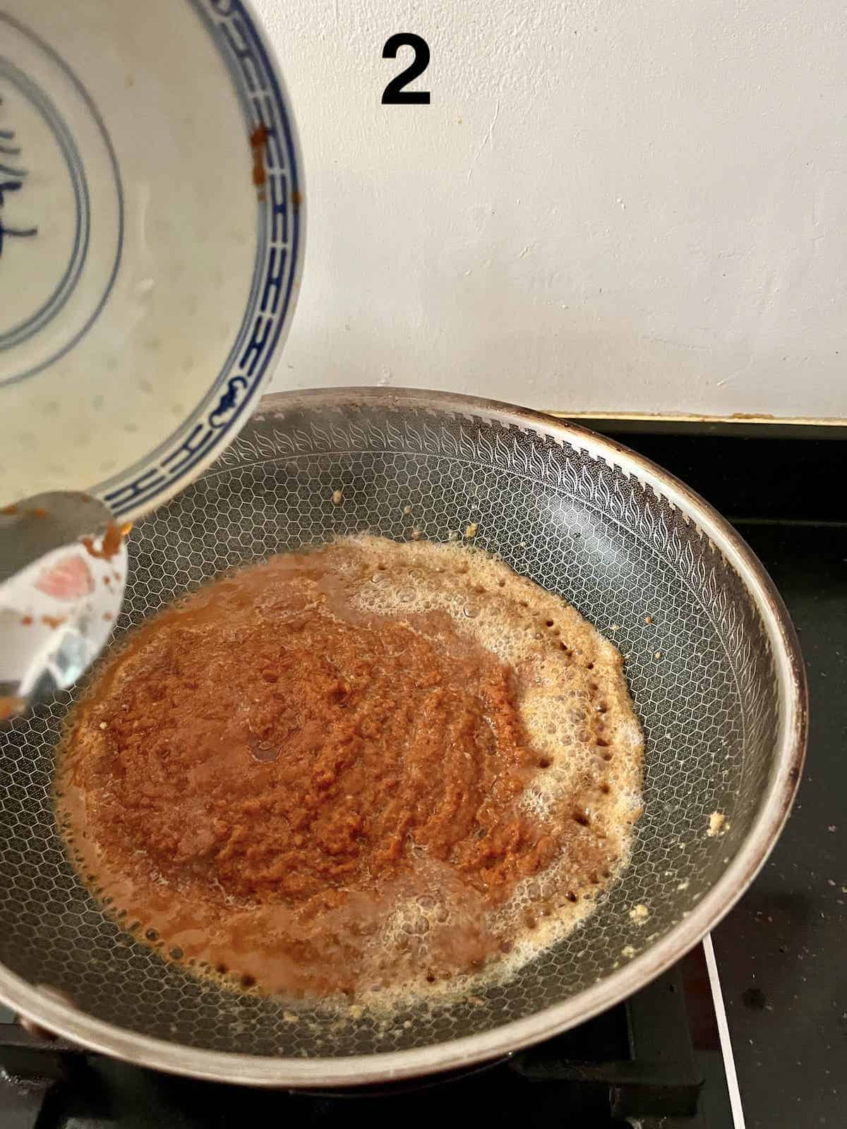 Stir-frying the rempah and dried prawns till fragrant.