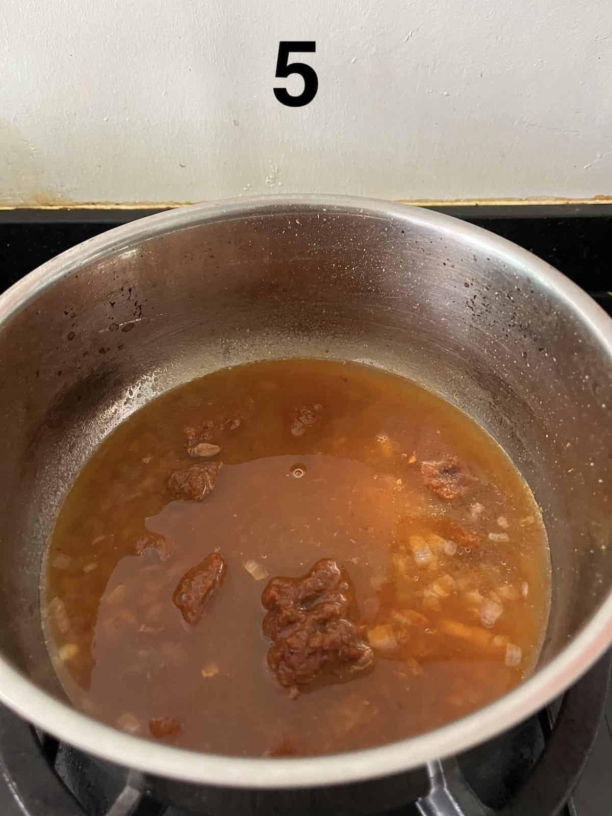 Bringing the ingredients for the Mee Siam Soup to a boil.