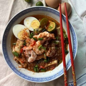 An overhead shot of a bowl of Singapore Wet Mee Siam with soup.