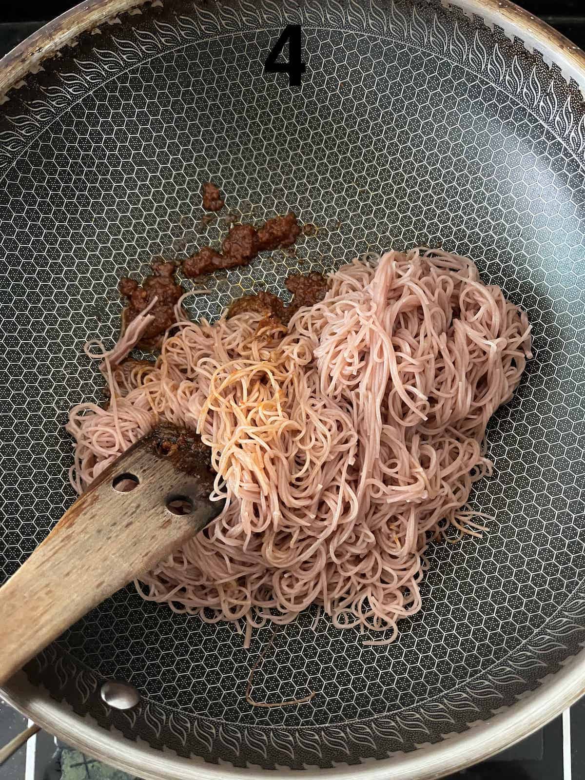 Stir frying the rice noodles with the Mee Siam rempah to make it more fragrant.