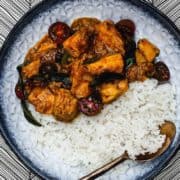 Indian Chicken Chukka with rice on a blue plate.