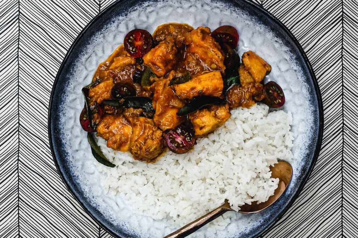 Indian Chicken Chukka with rice on a blue plate.