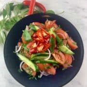 Indian cucumber salad in a dark blue bowl.