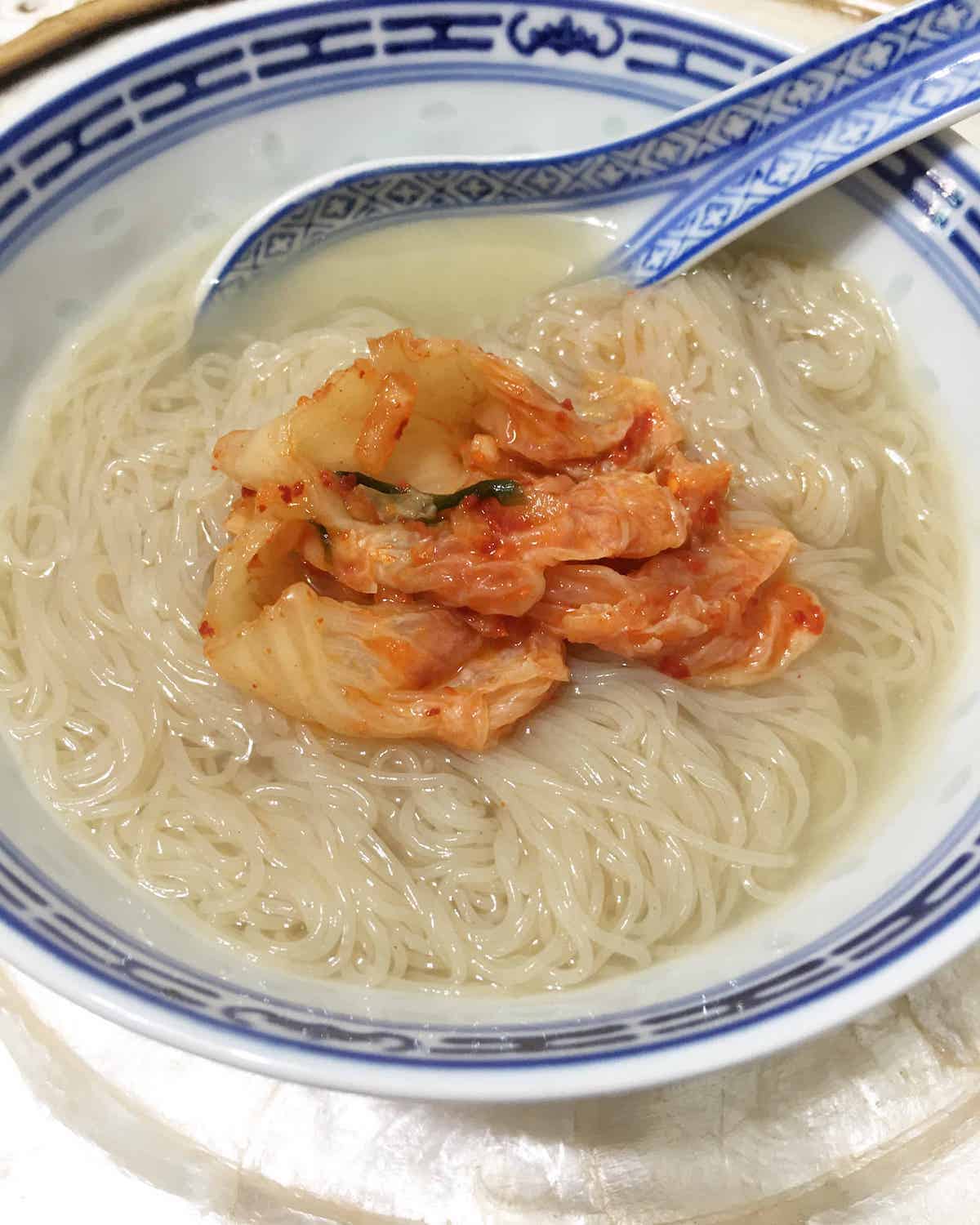 Bowl of radish cold noodles with kimchi on top