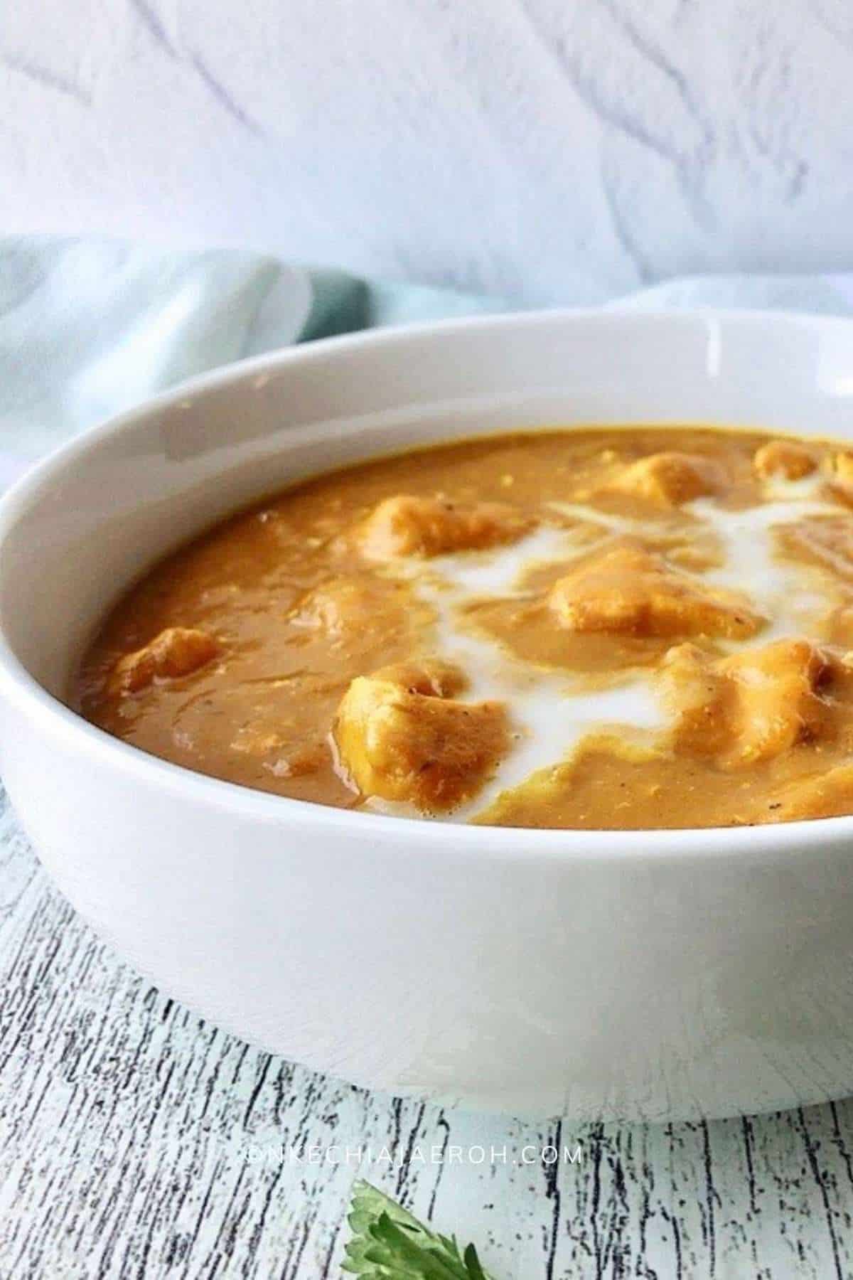 Mango and chicken curry in a white bowl.