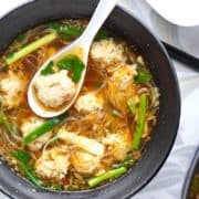 A bowl of Thai glass noodles soup with meatballs.