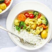 A bowl of yellow vegan curry and rice.