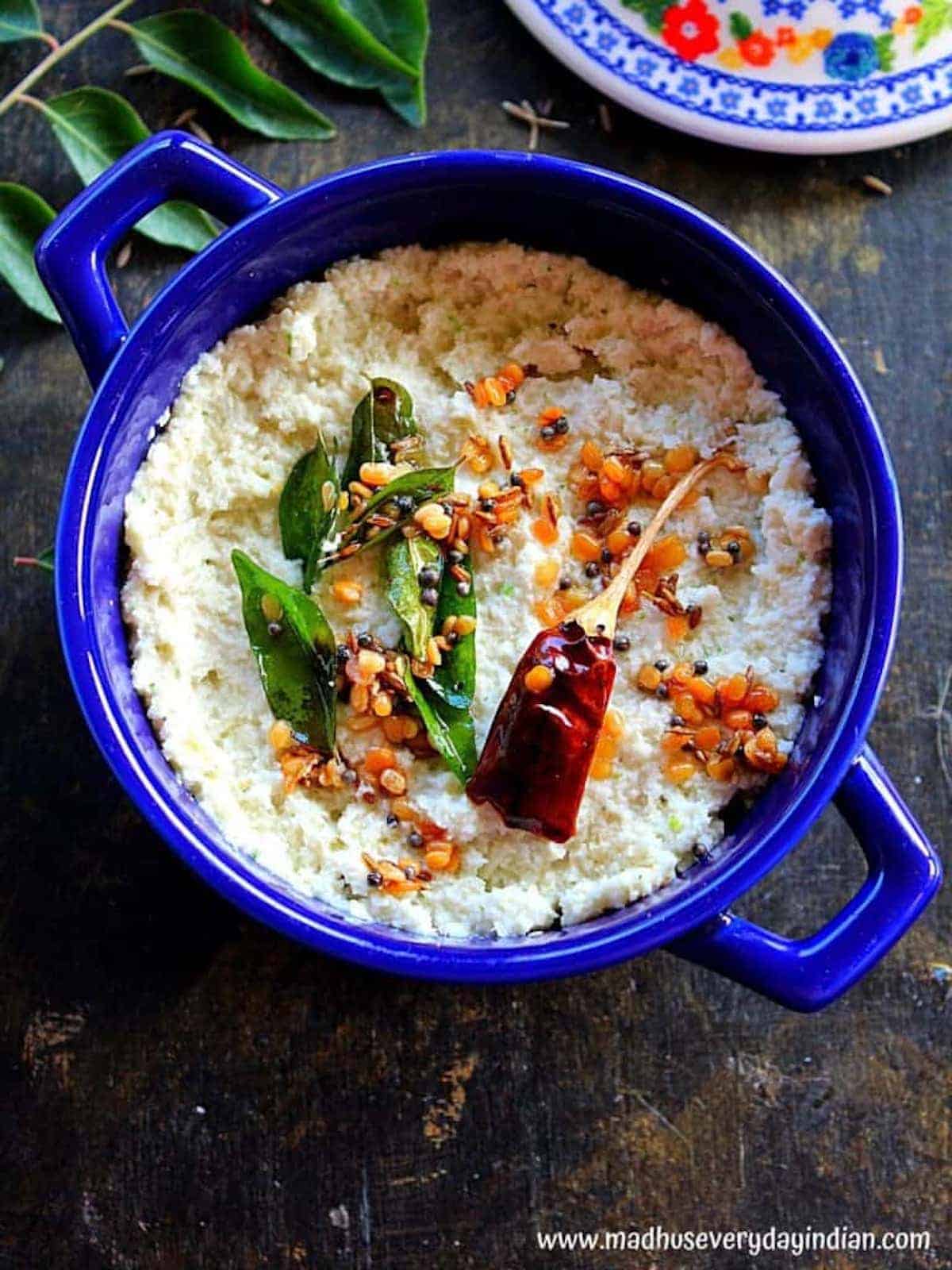 Dessicated coconut and curry leaf chutney in a blue bowl.