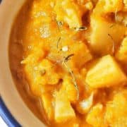 Close-up of a pot of yellow aloo gobi curry.