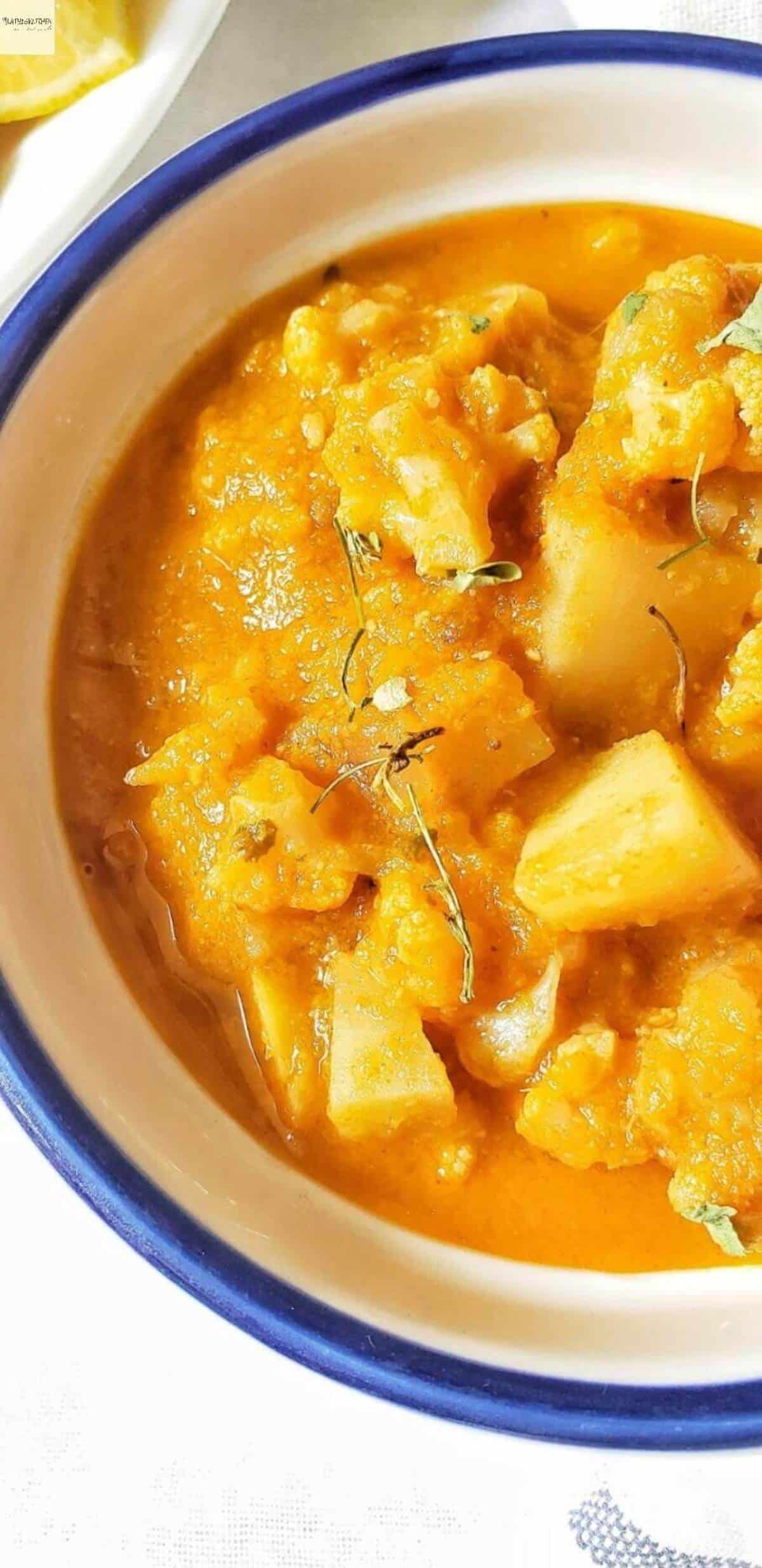 Close-up of a pot of yellow aloo gobi curry.