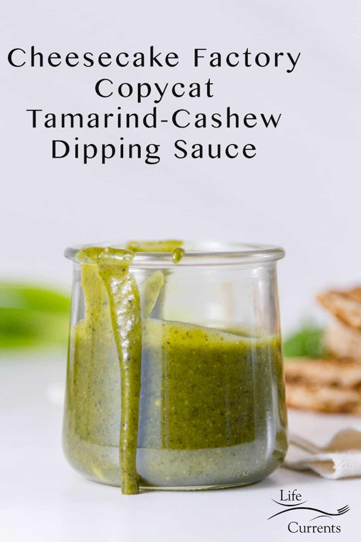 A green tamarind sauce in a glass container.