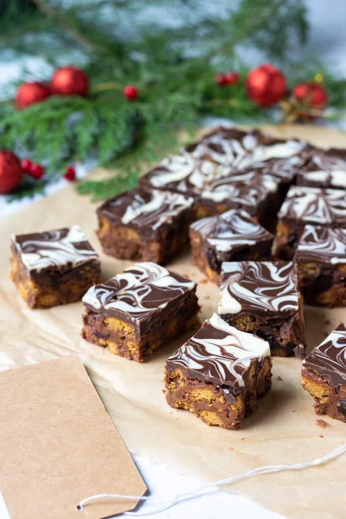 Sliced squares of chocolate tiffin cake on brown paper