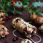 A few very pretty granola bars tied up with parchment paper and string scattered amongst holly leaves