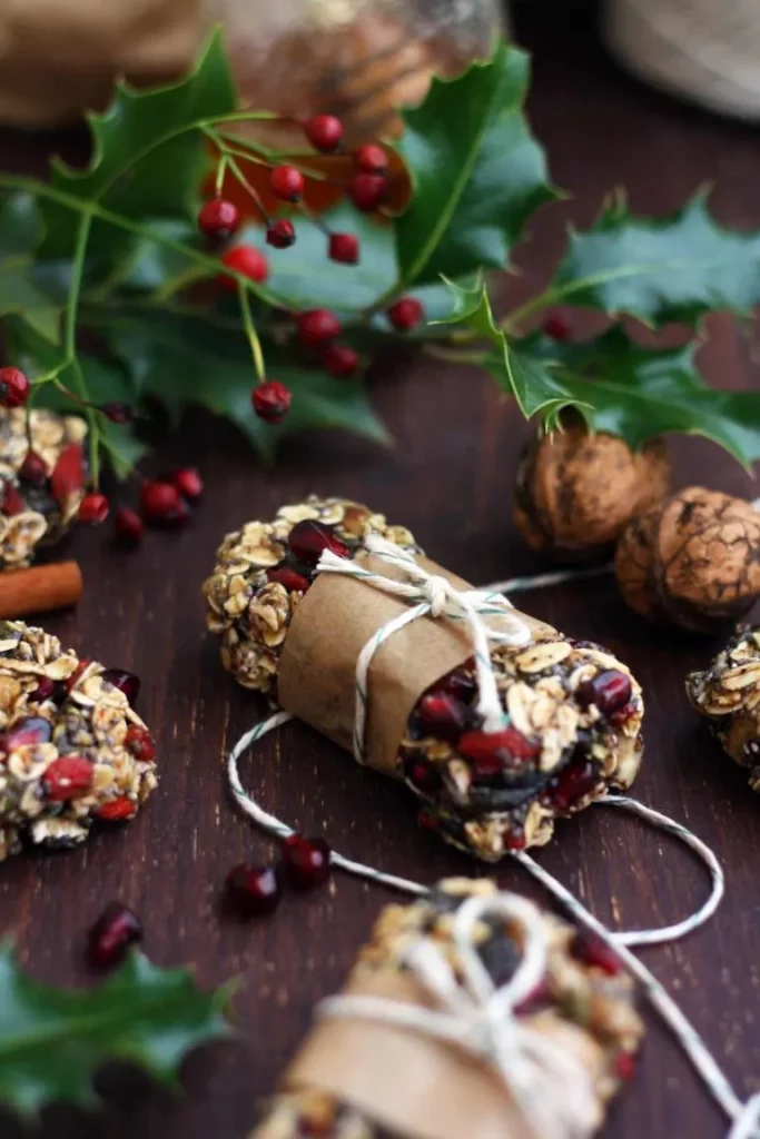A few very pretty granola bars tied up with parchment paper and string scattered amongst holly leaves