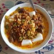 Close-up of lontong and veggie curry.