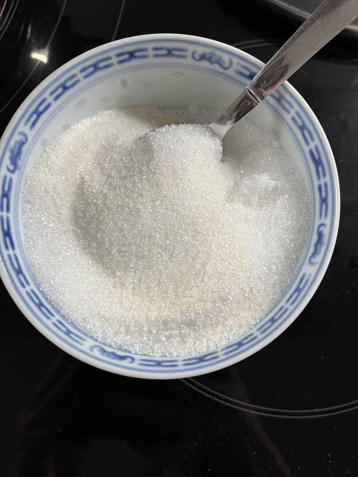 Konnyaku powder being mixed with white sugar in a bowl.