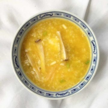 Bowl of golden pumpkin fish porridge with king oyster mushrooms