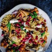 A colorful plate of samso chaat topped with tamarind dressing.