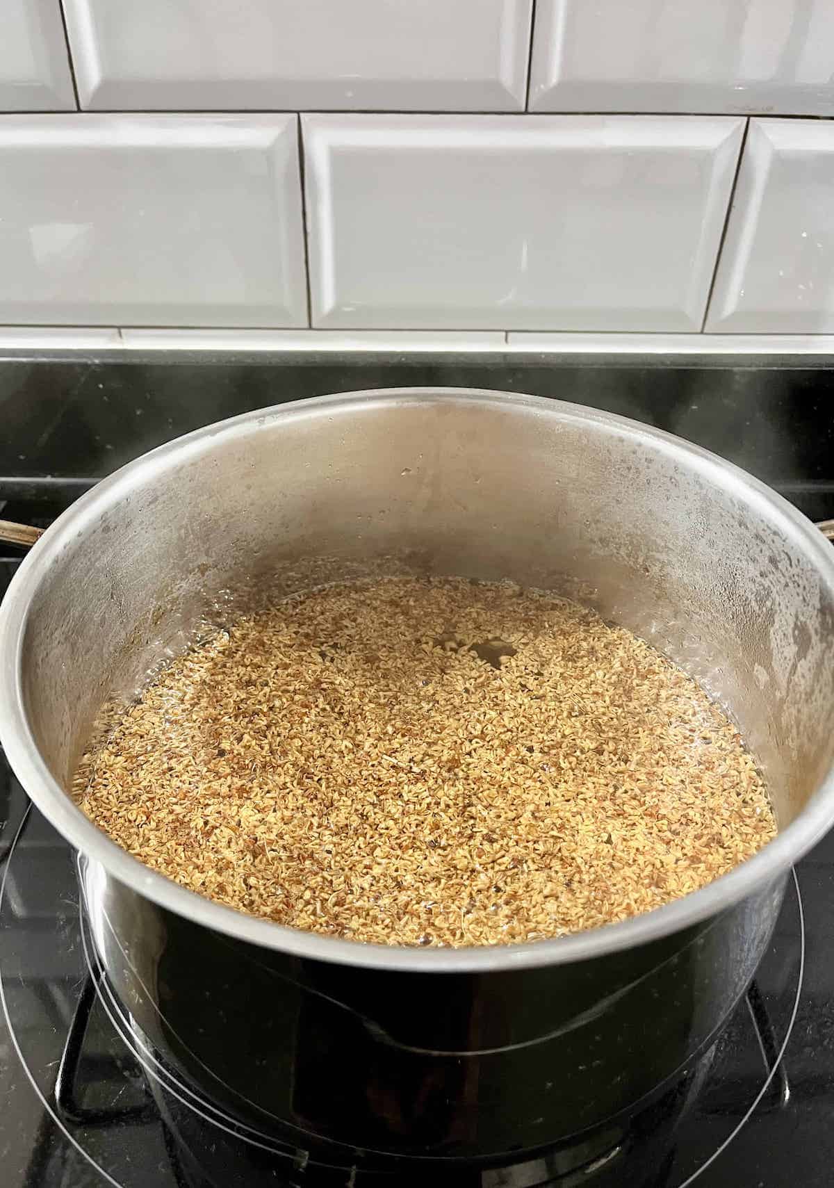 Osmanthus flowers simmering in a pot of almost boiling water.