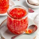 A glass jar full of a bright red sweet chilli sauce