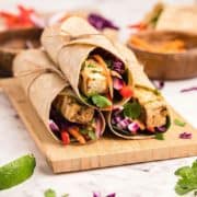 3 tofu wraps on a wooden board.