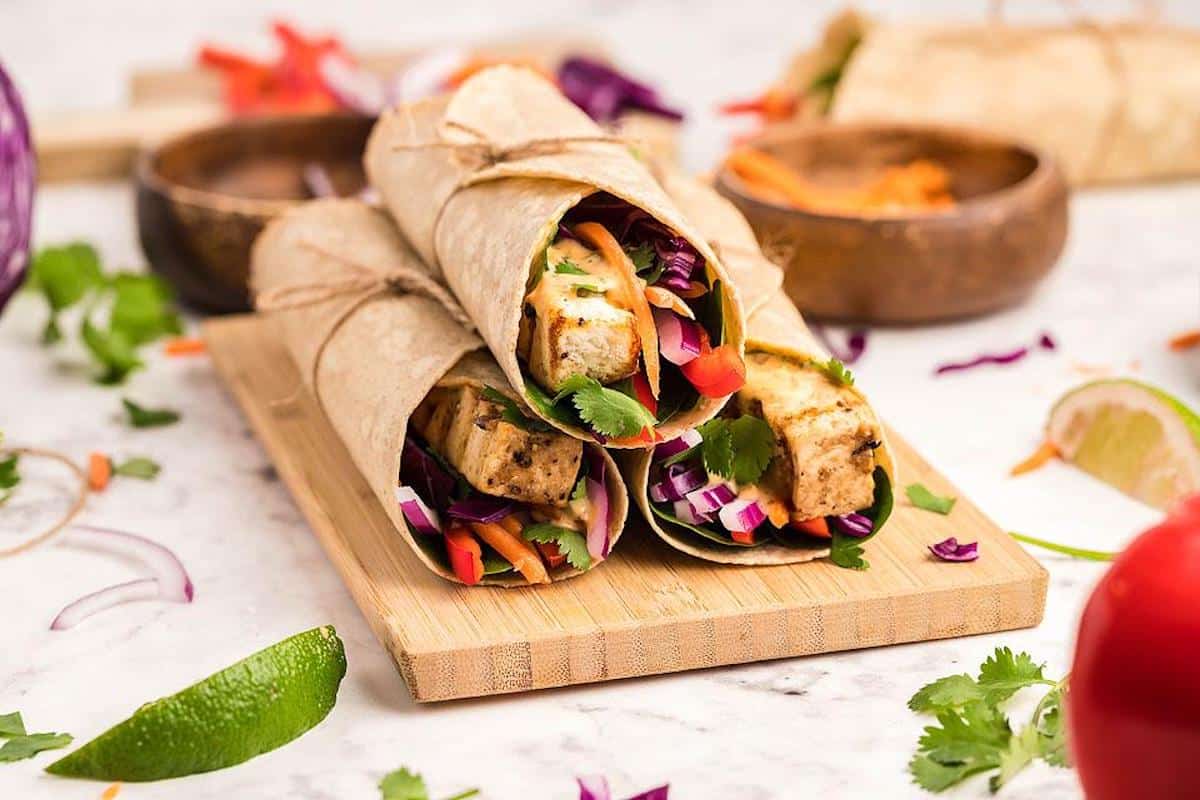 3 tofu wraps on a wooden board.