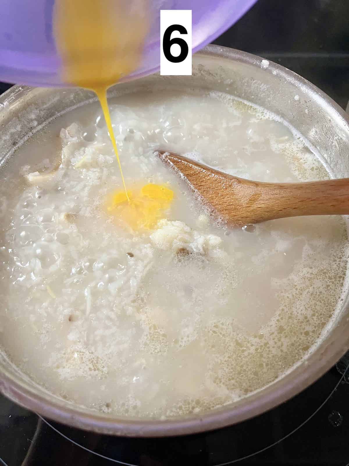 Adding egg yolk to a pot of congee.
