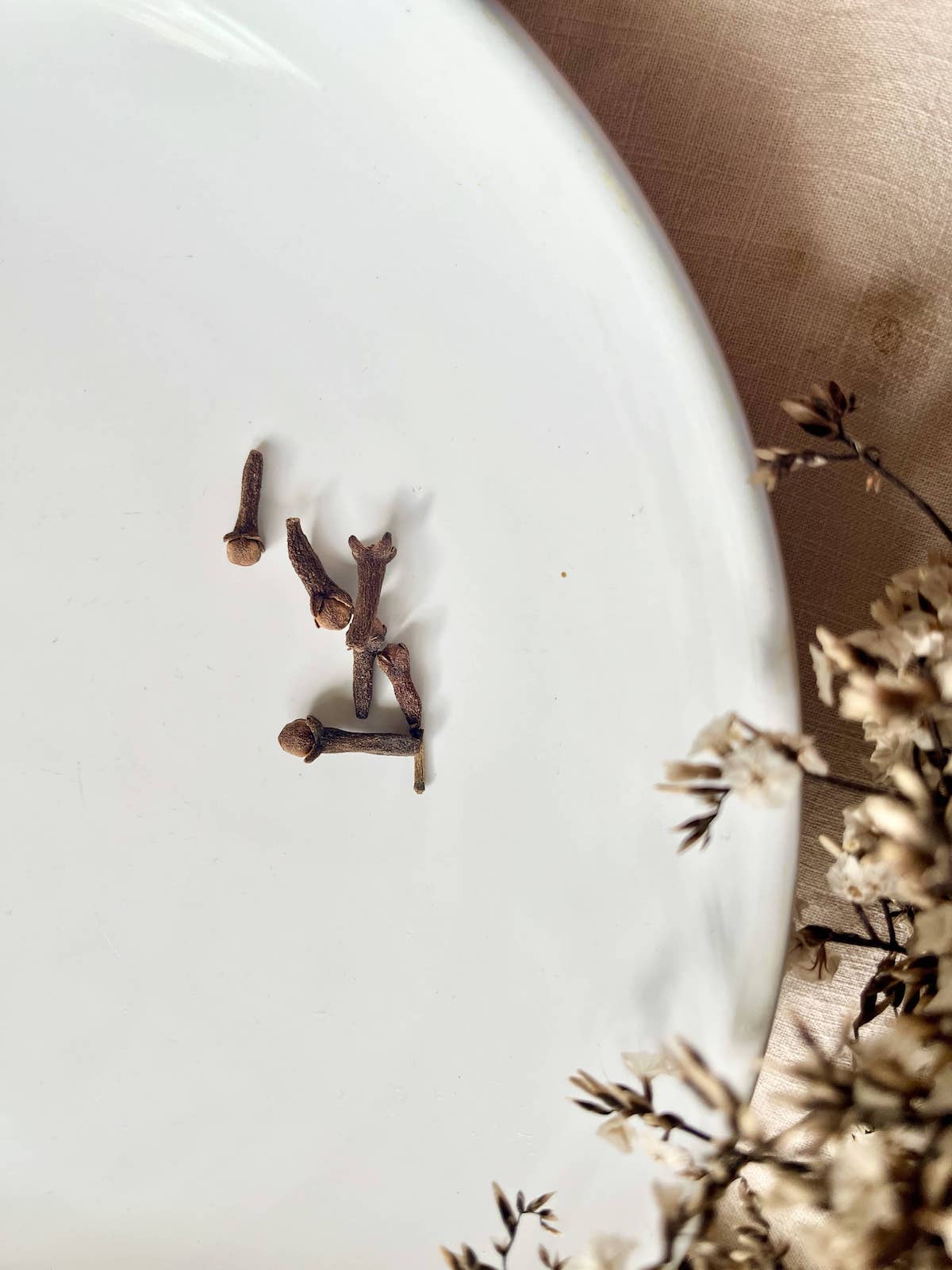 A few cloves on a white plate.