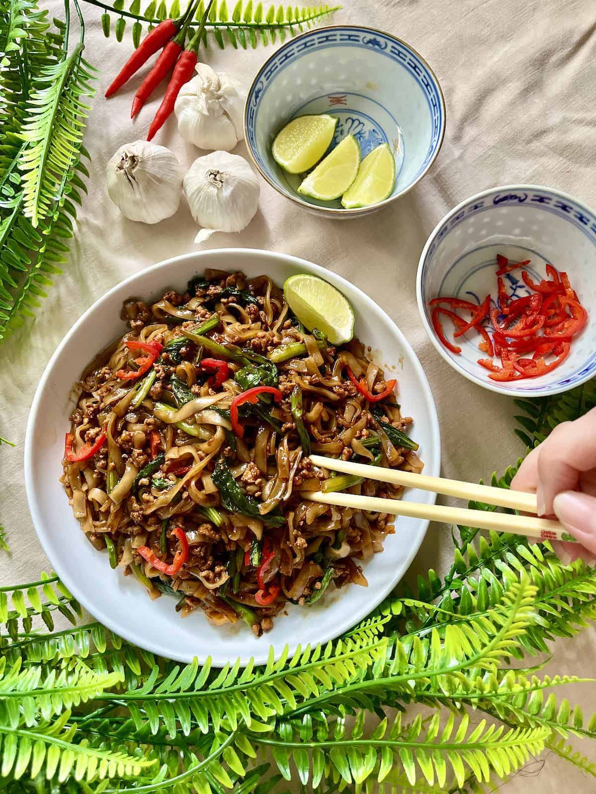 A plate of Thai pad kee mao next time lime, garlic and chilies.