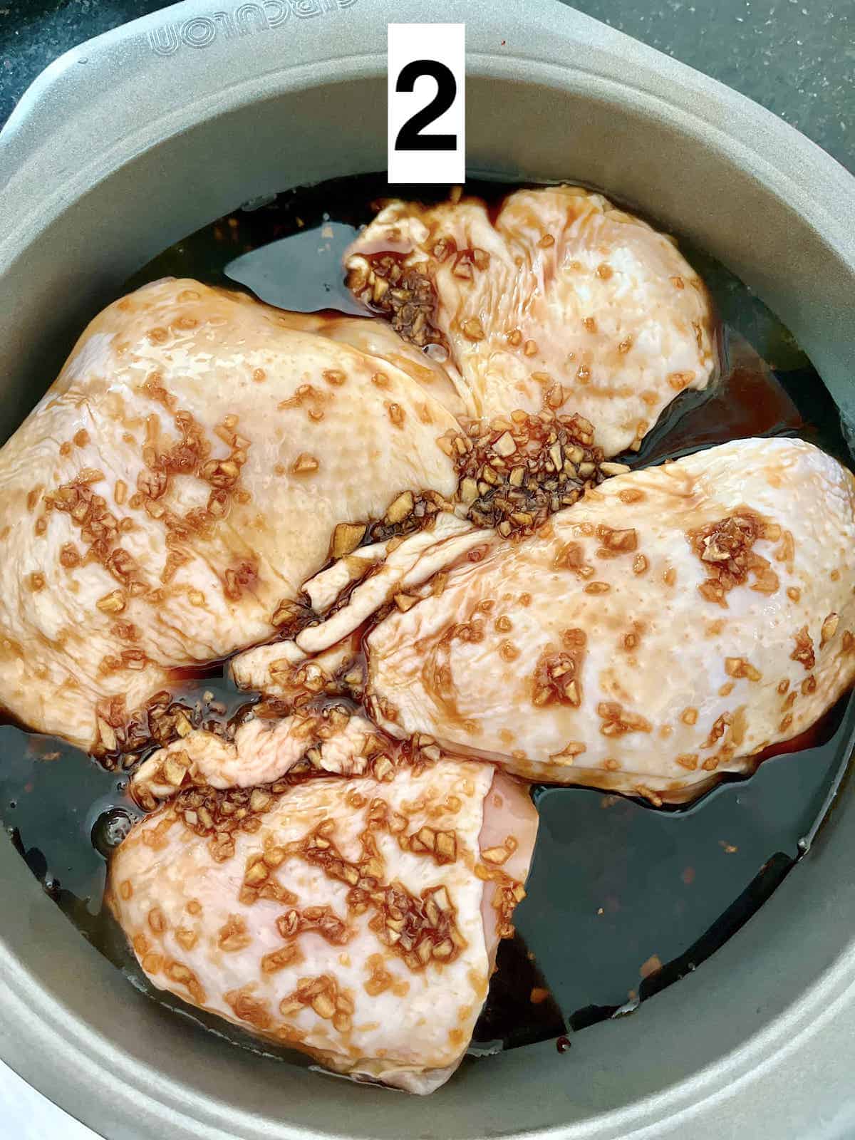 Chicken thighs with the skin on in a single layer in a baking pan.