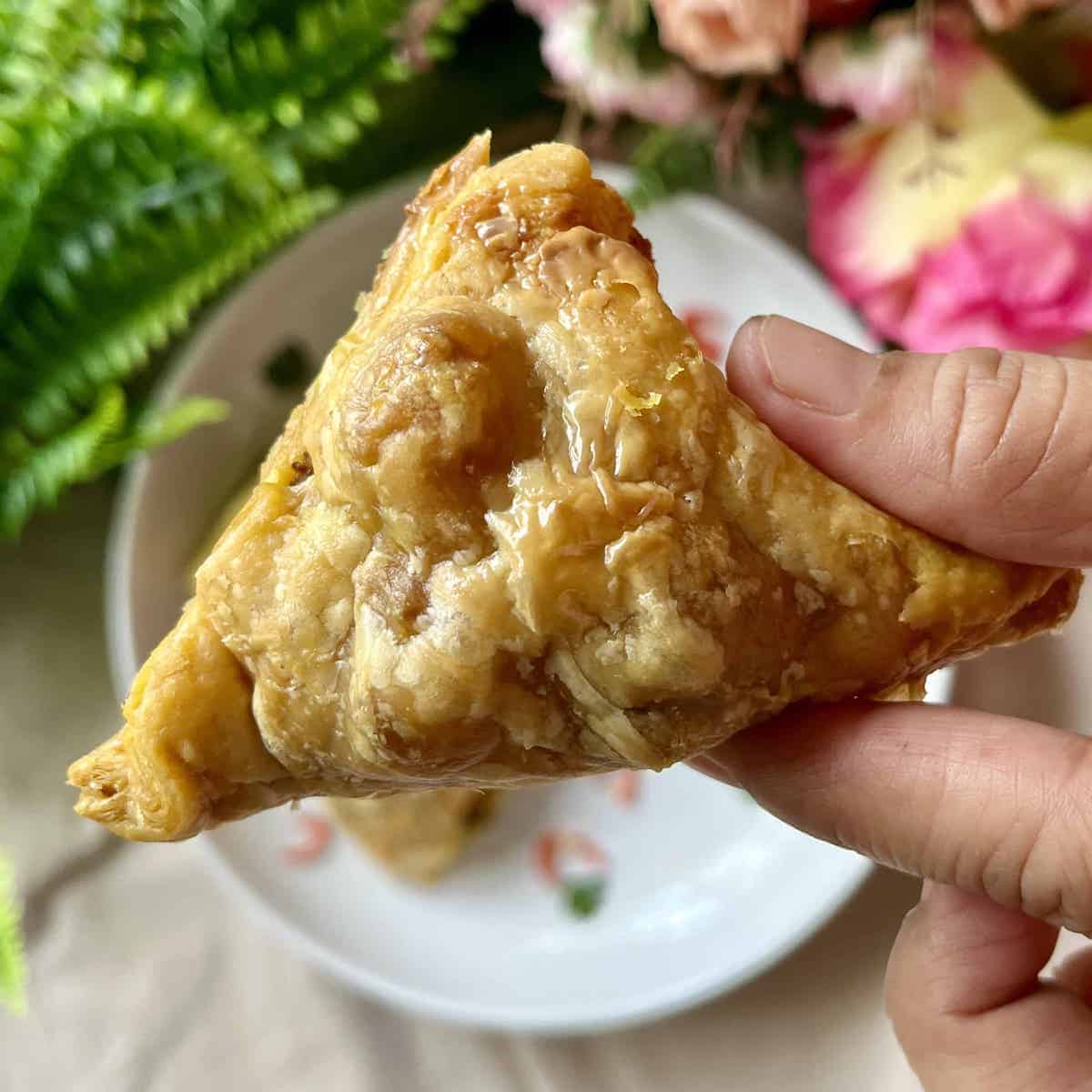 Close-up of a puff pastry samosa.