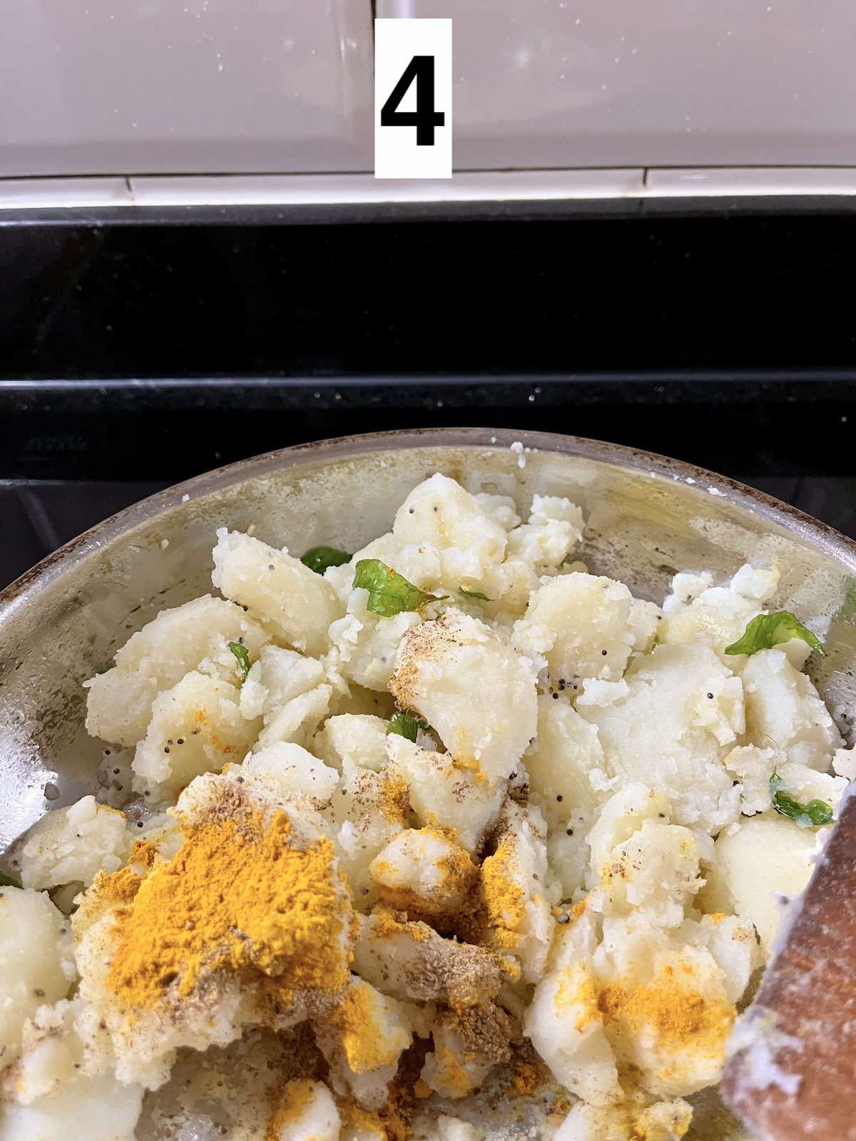 Sauteeting potato with turmeric powder, garam masala and other ingredients.