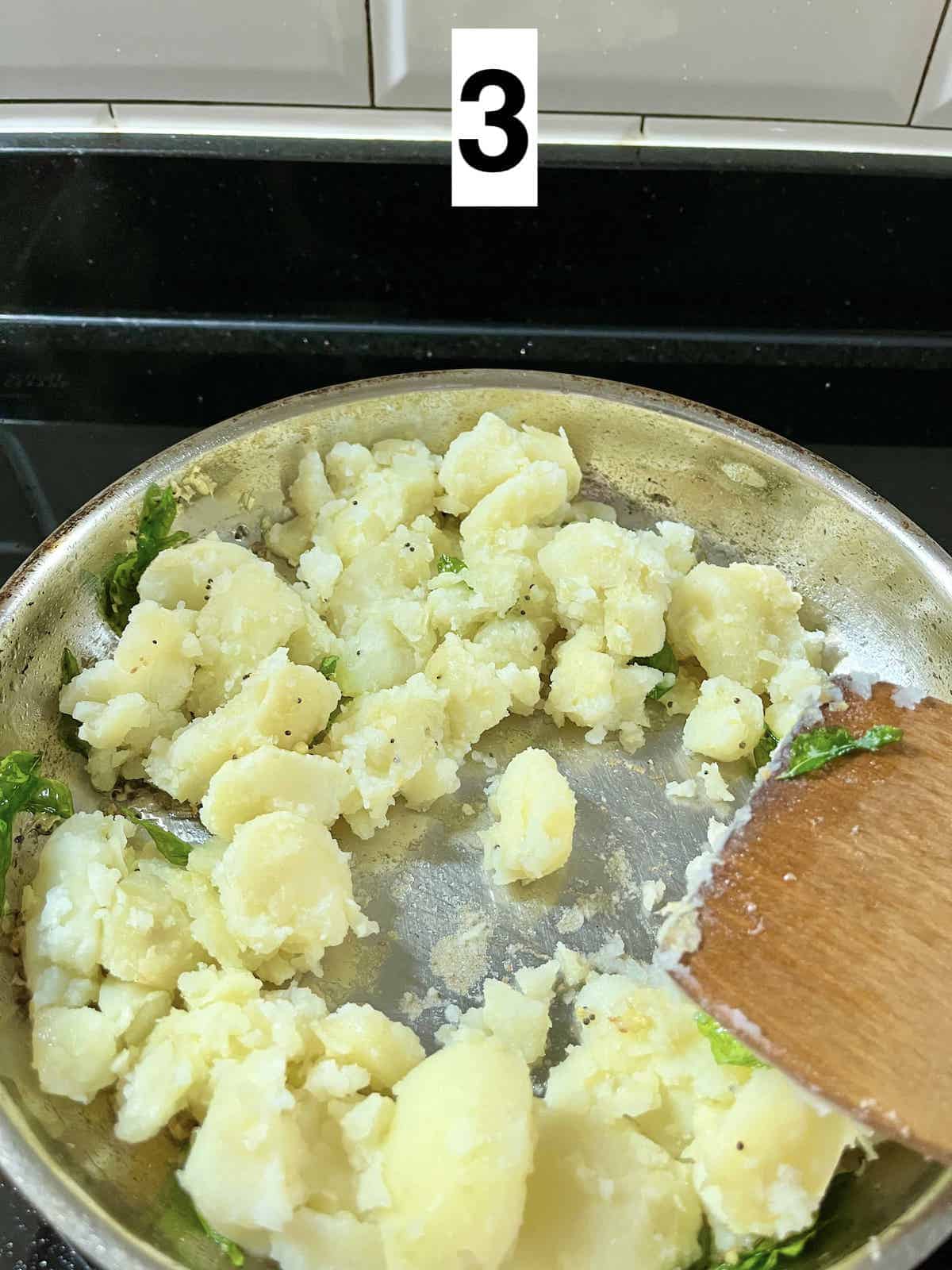 Sauteeting crumbled potatoes in a pan.