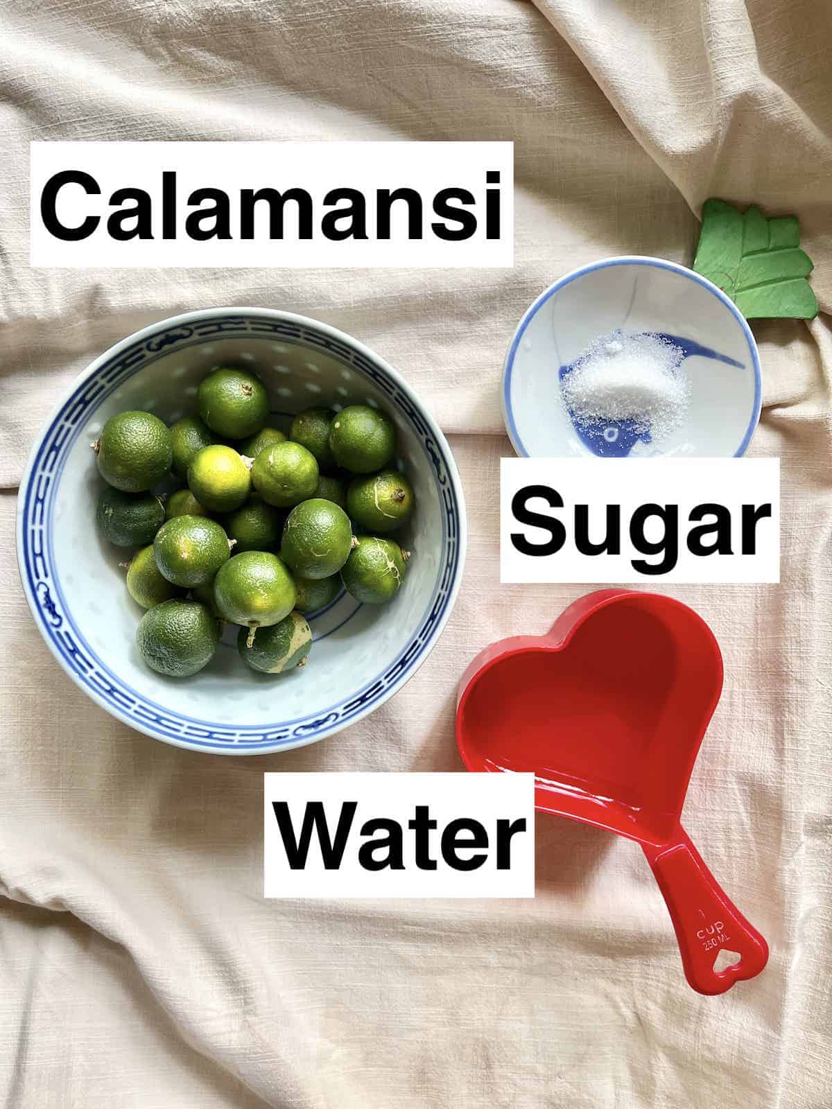 A bowl of calamondin limes next to water and sugar.