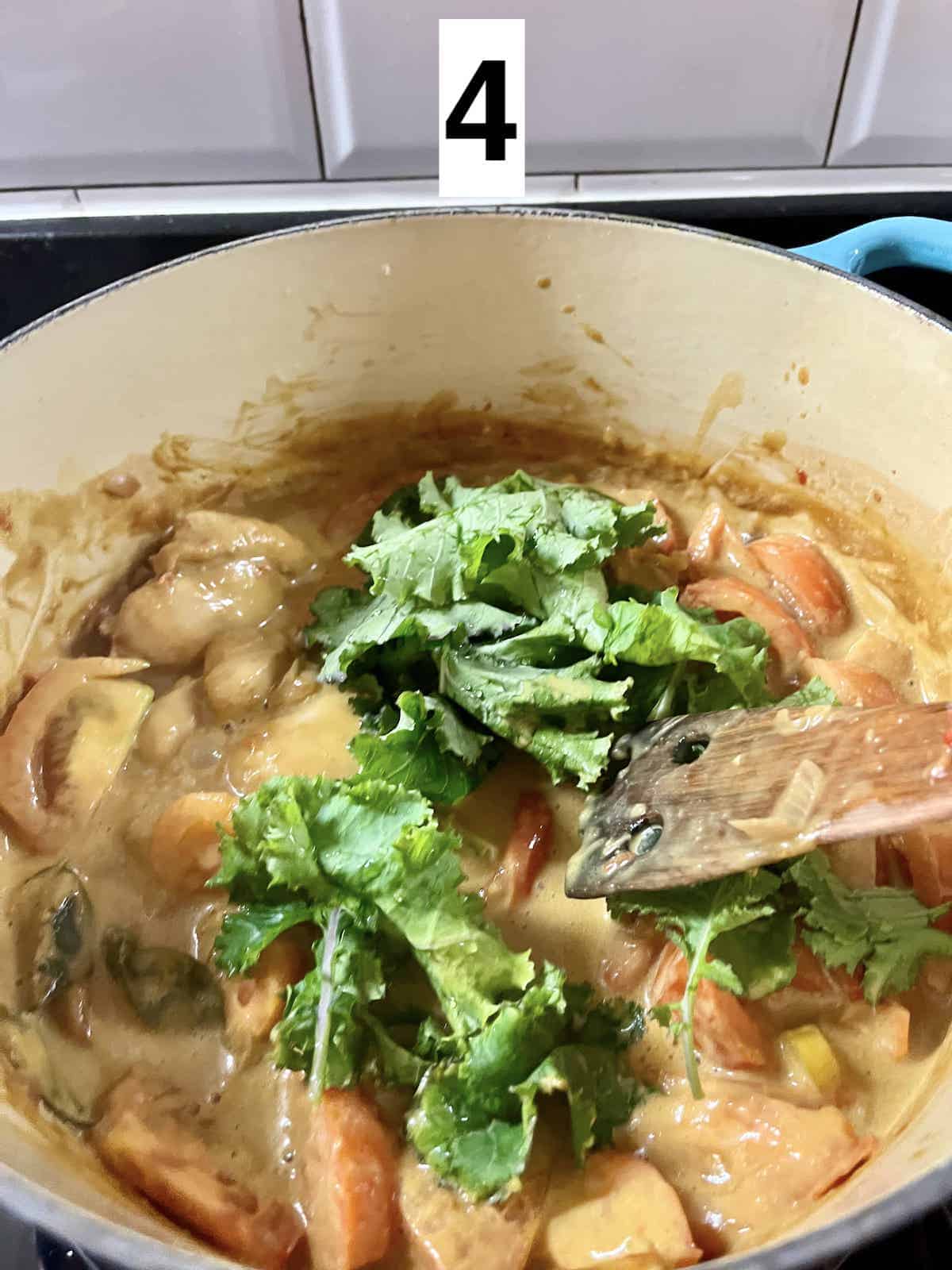 Adding kale to a pot of sambal coconut chicken curry.