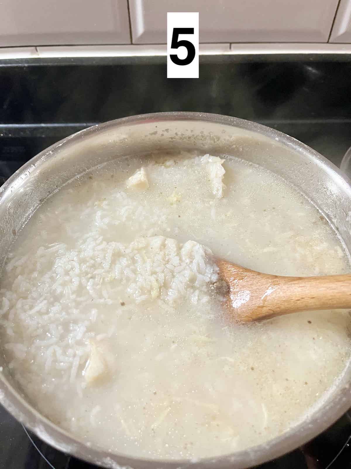 Stirring a pot of fish congee.