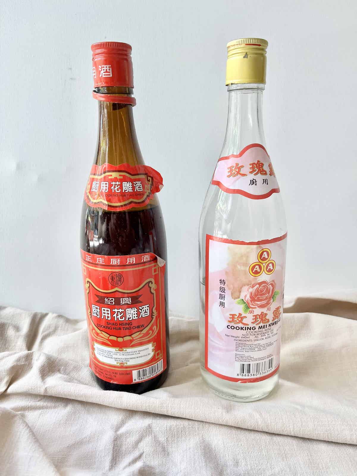 A bottle of Shaoxing to the left of a bottle of Mei Kwei Lu Jiu.