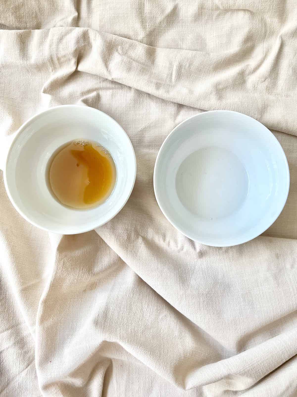 A bowl of Shaoxing wine to the left of a bowl of Chinese Rose Wine.