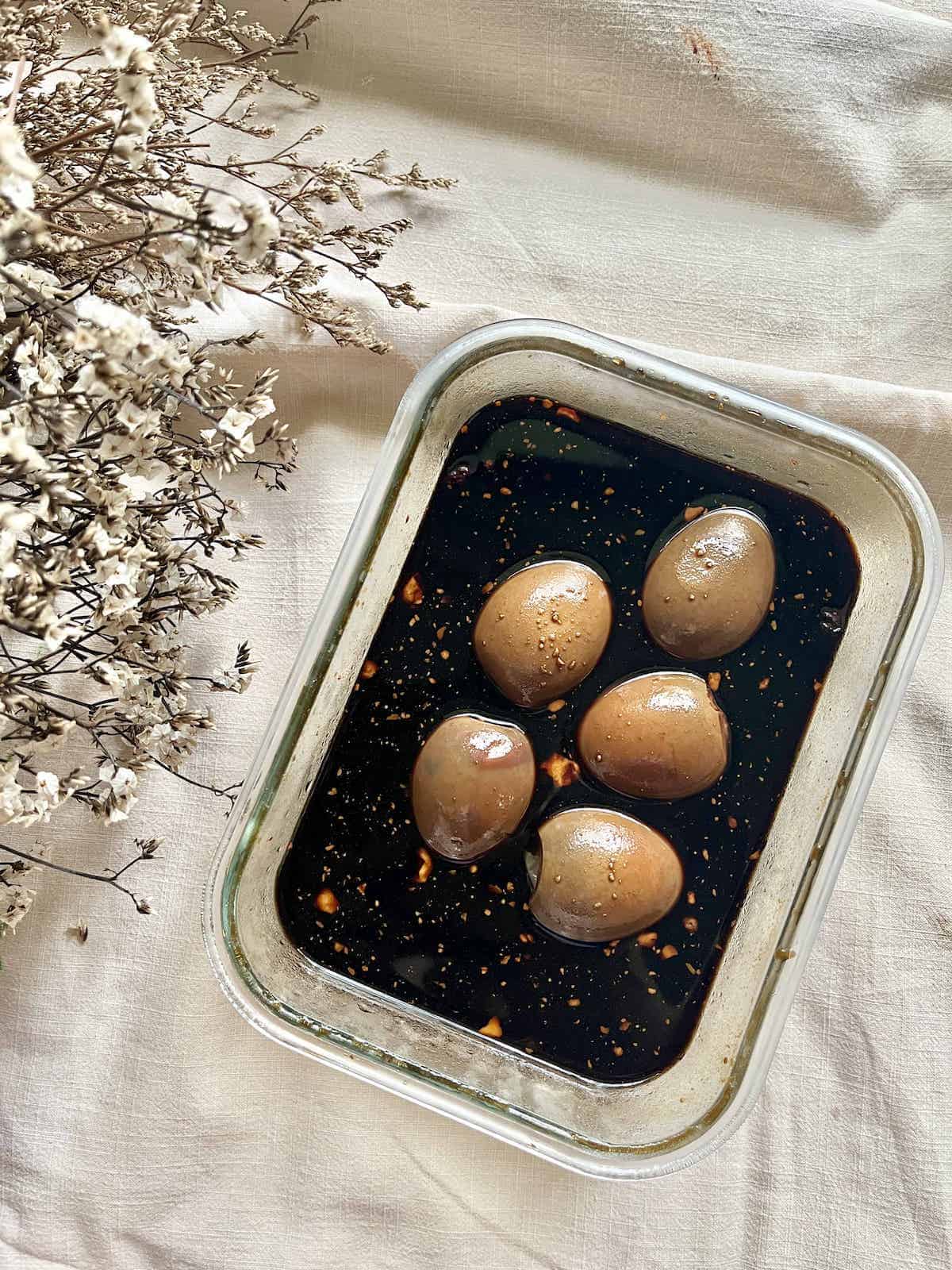 5 hard boiled eggs sitting in a soy marinade.