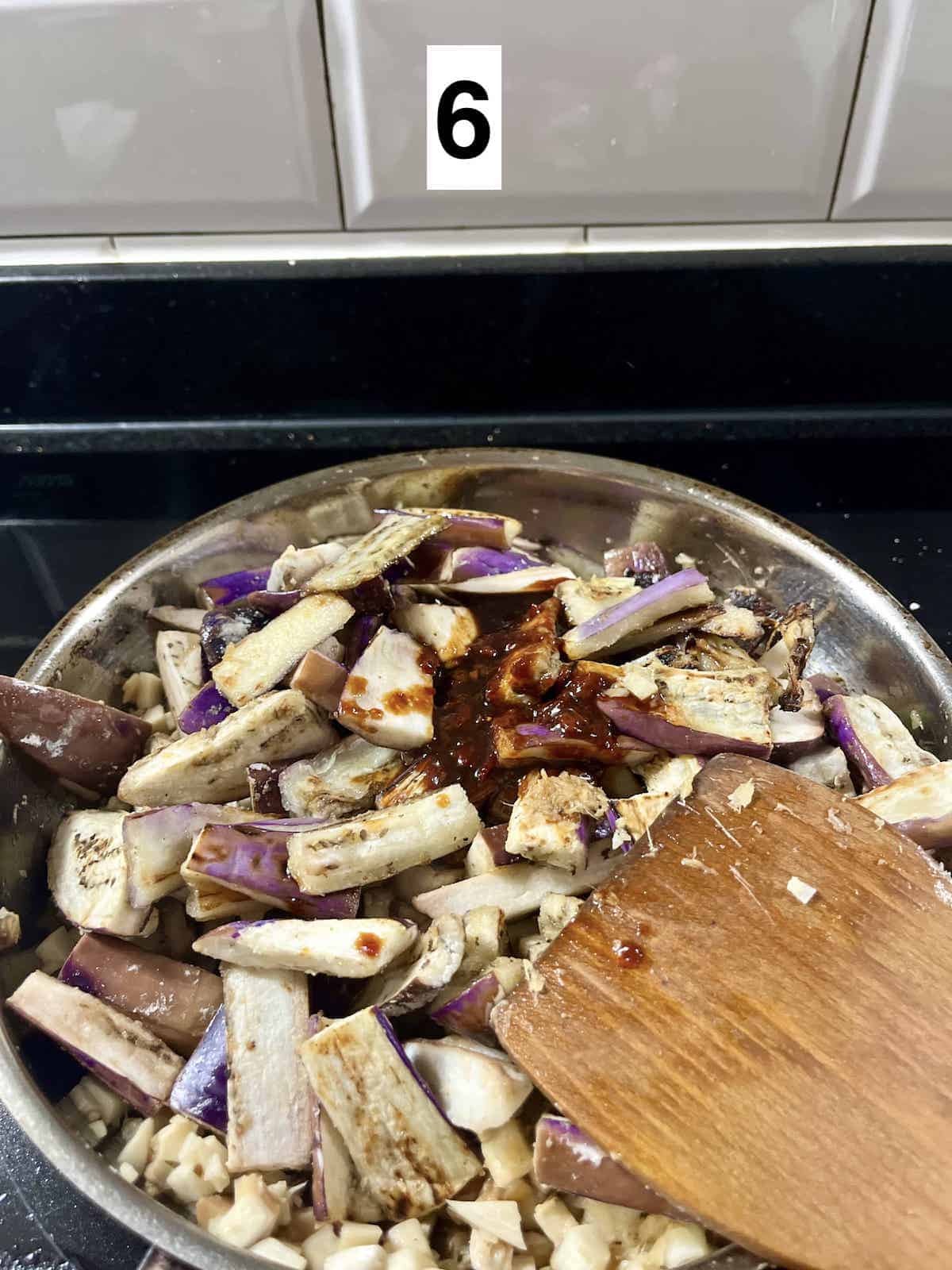 Adding sauce to stir-fried eggplants.