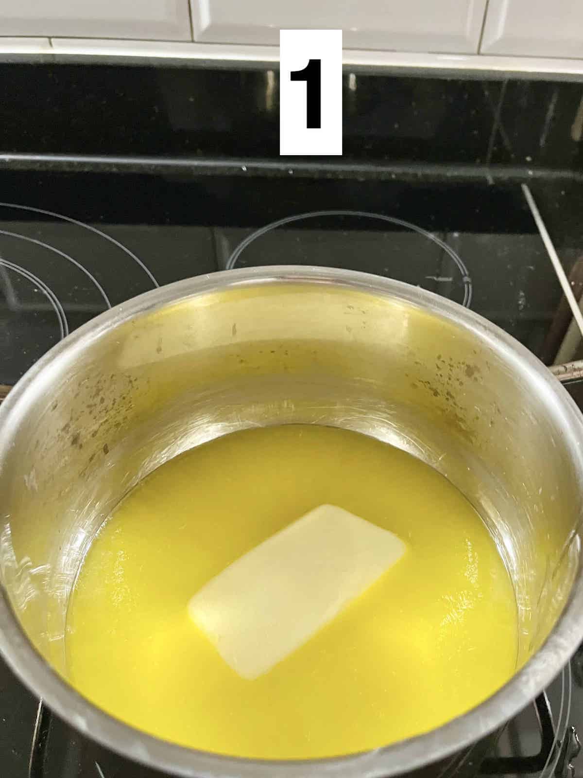 Butter melting slowly in a silver pot over an induction stove.