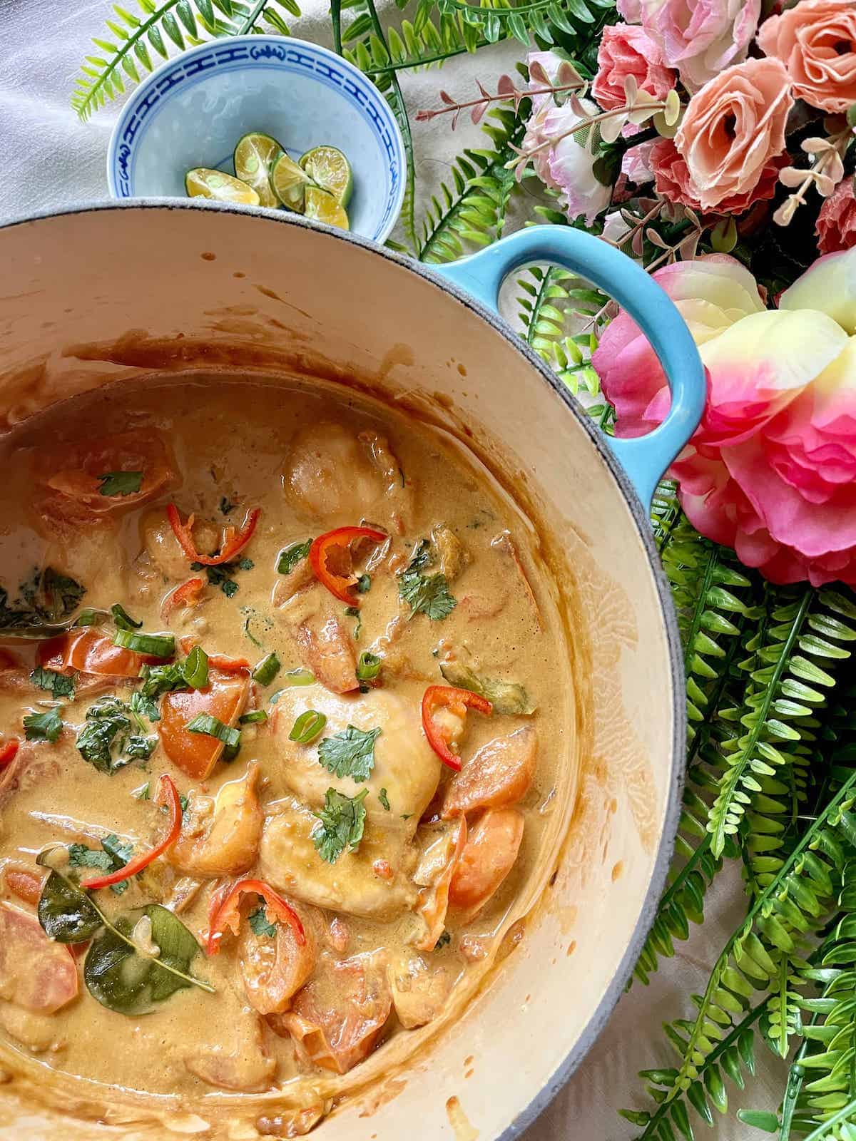 Close-up of chicken sambal with coconut sauce and kale.